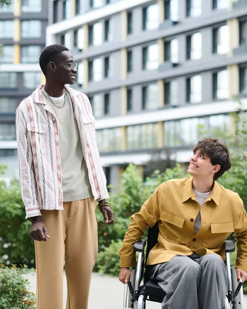 Disabled man in wheelchair outside with friend
